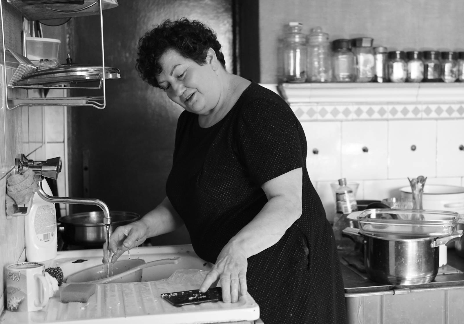 A woman in black and white is cutting food